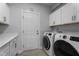 Bright laundry room with washer, dryer, white cabinets, and convenient exterior door at 412 Kavanaugh Rd, Wake Forest, NC 27587