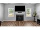 Bright living room featuring a fireplace, large windows, and wood flooring at 412 Kavanaugh Rd, Wake Forest, NC 27587