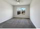 Clean bedroom with plush carpet, a ceiling fan, and a window overlooking the backyard at 4169 Weavers Pond Dr, Zebulon, NC 27597