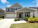 Charming two-story home with a covered front porch, manicured lawn, and attached two-car garage at 4169 Weavers Pond Dr, Zebulon, NC 27597