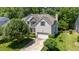 Beautiful home with a two-car garage, gray siding, stone accents, and a lush, tree-filled yard at 4608 Regency Dr, Durham, NC 27713