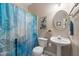 Small bathroom features a pedestal sink, neutral paint, and a blue dragonfly shower curtain at 4608 Regency Dr, Durham, NC 27713
