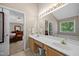 Bright bathroom with double sinks, a large mirror, and a view of the bath and bedroom at 4608 Regency Dr, Durham, NC 27713