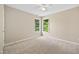 Neutral bedroom with carpet, two windows overlooking a wooded exterior, and ceiling fan at 4608 Regency Dr, Durham, NC 27713