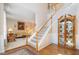 Bright foyer with hardwood floors, staircase, and a decorative curio cabinet at 4608 Regency Dr, Durham, NC 27713