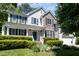 Charming two-story home featuring a welcoming front porch, stone accents, and lush landscaping at 4608 Regency Dr, Durham, NC 27713