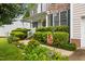 Home's inviting entrance features lush bushes and a welcoming 'Welcome' sign at 4608 Regency Dr, Durham, NC 27713