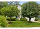 Charming two-story home with lush landscaping, manicured lawn, and mature trees providing shade at 4608 Regency Dr, Durham, NC 27713
