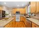 Well-lit kitchen featuring stainless appliances, granite countertops, and a functional island at 4608 Regency Dr, Durham, NC 27713