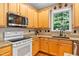 Well-lit kitchen with light wood cabinets, granite countertops, modern appliances, and a garden window at 4608 Regency Dr, Durham, NC 27713