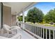 Relaxing porch with white wicker chairs overlooking a well-maintained yard and tree-lined street at 4608 Regency Dr, Durham, NC 27713