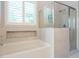Luxurious bathroom with a separate tub and glass-enclosed shower, with tiled walls and window at 49 Mount Joy Pl, Sanford, NC 27330