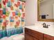 A colorful bathroom features a patterned shower curtain and a dark wood vanity with a white countertop at 49 Mount Joy Pl, Sanford, NC 27330