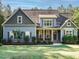 Charming home with blue siding, stone accents, mature landscaping, and a welcoming front porch at 49 Mount Joy Pl, Sanford, NC 27330