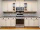 Modern kitchen featuring a stainless steel oven, ample cabinetry, and stylish backsplash at 49 Mount Joy Pl, Sanford, NC 27330