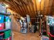 Unfinished attic featuring open rafters and storage shelves with various items at 506 Wildwood Ln, Graham, NC 27253