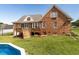 Brick home featuring a screened-in porch, deck, well-kept lawn, and an above-ground pool at 506 Wildwood Ln, Graham, NC 27253