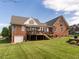 Brick home featuring a screened-in porch and deck, and well-kept lawn in a landscaped backyard at 506 Wildwood Ln, Graham, NC 27253