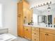 Elegant bathroom featuring dual sinks, wooden cabinets, a large mirror, and a separate soaking tub at 506 Wildwood Ln, Graham, NC 27253