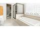 Bathroom featuring a tiled tub, glass shower, and a modern design at 506 Wildwood Ln, Graham, NC 27253