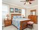 Comfortable bedroom with a wooden bed, ceiling fan, and warm, neutral decor at 506 Wildwood Ln, Graham, NC 27253