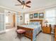 Cozy bedroom with a wooden bed frame, ceiling fan, and bright natural lighting at 506 Wildwood Ln, Graham, NC 27253