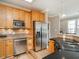 Bright and updated kitchen with stainless steel appliances, wood cabinets, granite countertops, and hardwood floors at 506 Wildwood Ln, Graham, NC 27253