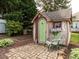 Charming backyard playhouse featuring a unique design, stone patio, and a decorative garden at 506 Wildwood Ln, Graham, NC 27253
