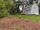 View of the backyard, with a light-blue two-story house, wooden deck, and pine straw landscaping at 509 Olive Branch Rd, Durham, NC 27703