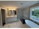 Modern bathroom with double vanity, glass shower, and soaking tub under a window at 509 Olive Branch Rd, Durham, NC 27703
