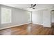 Bright bedroom featuring hardwood floors, neutral walls, a ceiling fan, and light-filled windows at 509 Olive Branch Rd, Durham, NC 27703