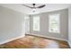 Well-lit bedroom boasts hardwood floors, neutral walls, a ceiling fan, and two light-filled windows at 509 Olive Branch Rd, Durham, NC 27703