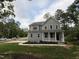New construction two-story home with board and batten siding, green lawn, and covered front porch at 509 Olive Branch Rd, Durham, NC 27703