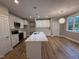 Modern kitchen with stainless steel appliances, white cabinets, and a kitchen island at 509 Olive Branch Rd, Durham, NC 27703