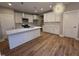 Modern kitchen with stainless steel appliances, white cabinets, and a kitchen island at 509 Olive Branch Rd, Durham, NC 27703