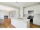 Open kitchen and living area with wood floors and stainless steel appliances at 509 Olive Branch Rd, Durham, NC 27703