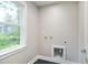 Compact laundry room featuring black tile floor, neutral walls, and hook-ups with a window at 509 Olive Branch Rd, Durham, NC 27703