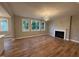 Living room with hardwood flooring, fireplace, and windows at 509 Olive Branch Rd, Durham, NC 27703