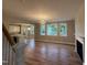 Open living room featuring a modern chandelier, fireplace, wood floors, and an open doorway to the kitchen at 509 Olive Branch Rd, Durham, NC 27703