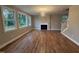 Spacious living room with hardwood floors, fireplace, and three large windows at 509 Olive Branch Rd, Durham, NC 27703