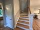 Elegant staircase featuring hardwood treads, white risers, and natural light, leading to the upper level of the home at 509 Olive Branch Rd, Durham, NC 27703