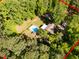 Aerial view of a home featuring a backyard pool, bordered by lush trees and offering privacy; approximate lot lines are shown in red at 525 Turtle Creek Farm Rd, Apex, NC 27523