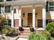 Inviting front entrance with classic columns, a warm wood door, and lovely planters at 525 Turtle Creek Farm Rd, Apex, NC 27523