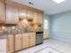 Well-lit kitchen with granite countertops, tiled backsplash, stainless steel appliances, and tile floors at 525 Turtle Creek Farm Rd, Apex, NC 27523