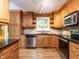 Well-lit kitchen featuring custom cabinetry, stainless steel appliances, and hardwood floors at 525 Turtle Creek Farm Rd, Apex, NC 27523