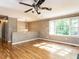 Bright living room with hardwood floors, a ceiling fan, and large windows at 525 Turtle Creek Farm Rd, Apex, NC 27523