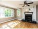 Sunlit living room featuring a fireplace, hardwood floors, and bright windows at 525 Turtle Creek Farm Rd, Apex, NC 27523