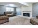 Cozy living room features a white brick fireplace, carpet floors, and a window providing ample natural light at 525 Turtle Creek Farm Rd, Apex, NC 27523