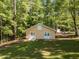Outbuilding with double doors and a well-maintained lawn, surrounded by lush trees, creating a private retreat at 525 Turtle Creek Farm Rd, Apex, NC 27523