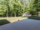 Outbuilding in a wooded area with a concrete patio in the foreground and well-maintained lawn at 525 Turtle Creek Farm Rd, Apex, NC 27523